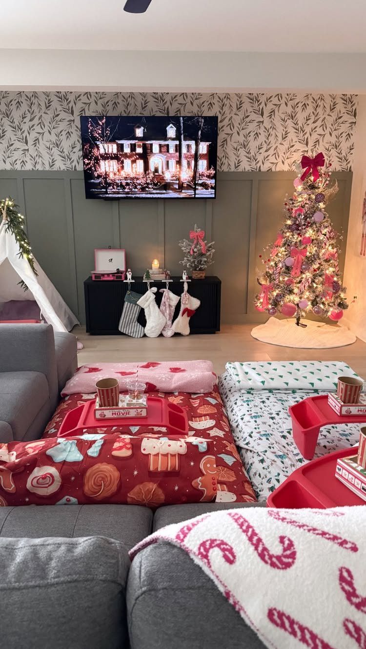 Festive indoor picnic setup with red trays and Christmas blankets in a decorated living room.