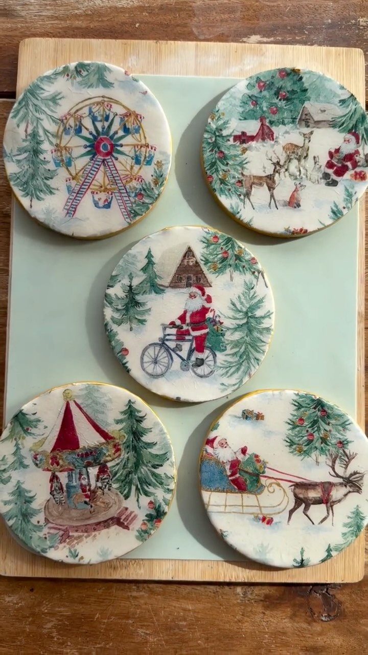 Five decorative Christmas themed coasters with vintage illustrations arranged on a light green board.