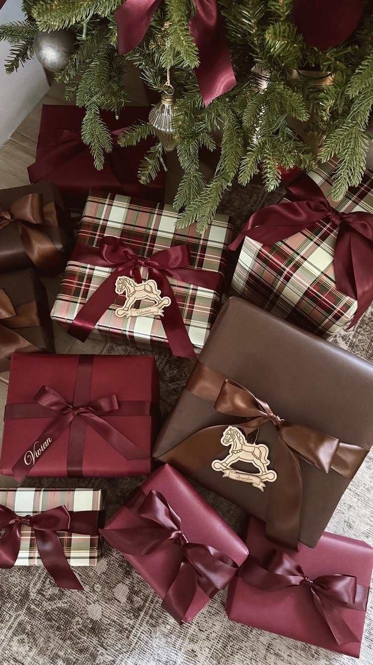 Decorating for Christmas: 12 Ideas That Work in Real Rooms 10 Wrapped Christmas gifts in burgundy, brown, and plaid with satin ribbons under a green tree.