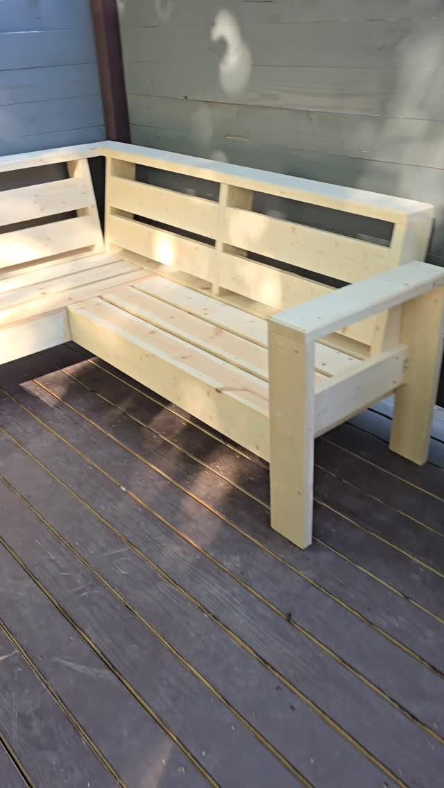 DIY Patio Couch: 8 Projects to Build for Any Budget 7 Unfinished light wood L-shaped sectional couch sitting on a dark wooden outdoor deck.