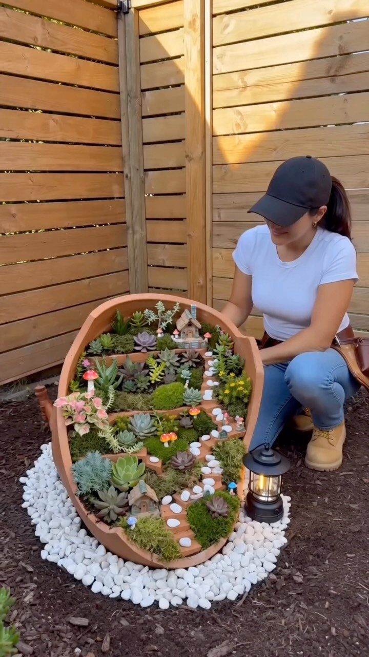 Easy Garden DIY: 18 Projects for a Yard That Feels Finished 18 A woman kneeling beside a large terracotta pot planter filled with diverse succulents and moss.