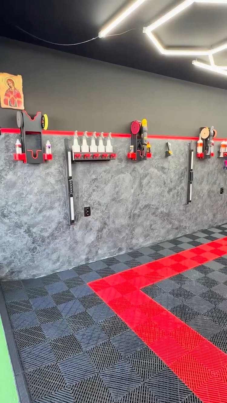 Grey and red interlocking garage floor tiles in a modern organized garage setting.