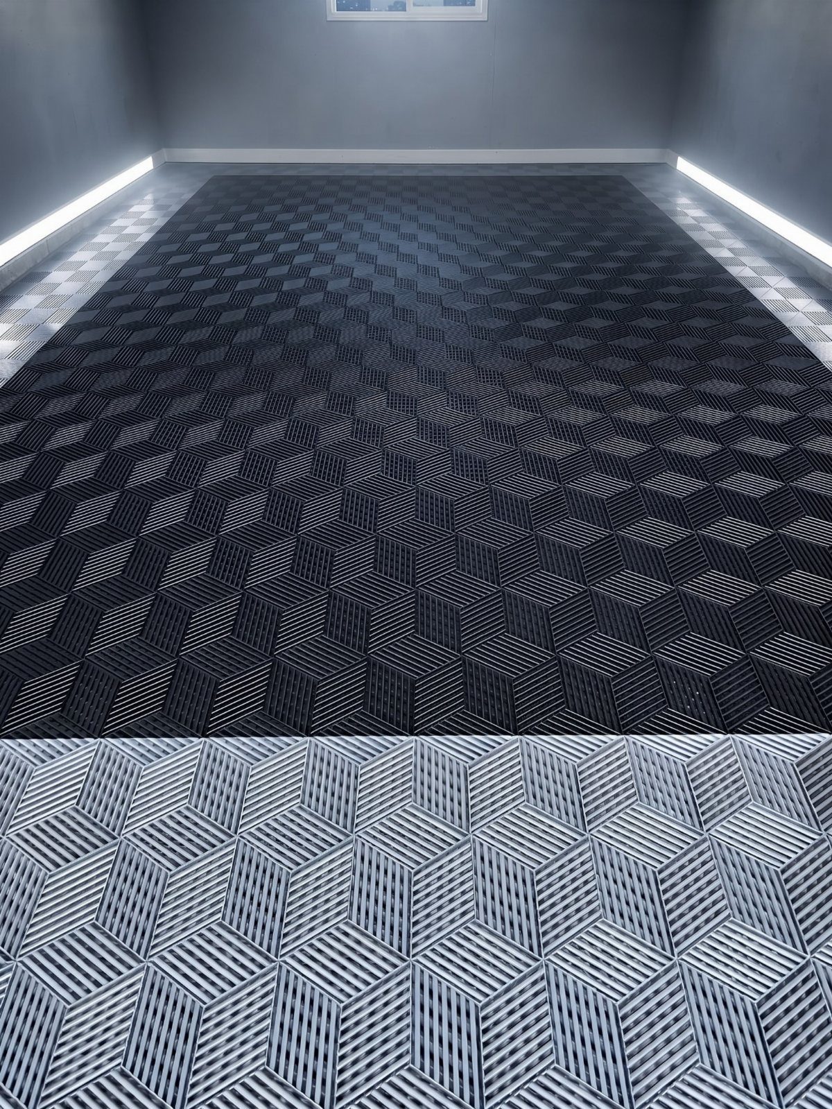 Ribbed interlocking garage floor tiles with a grey 3D geometric cube pattern under bright lights.