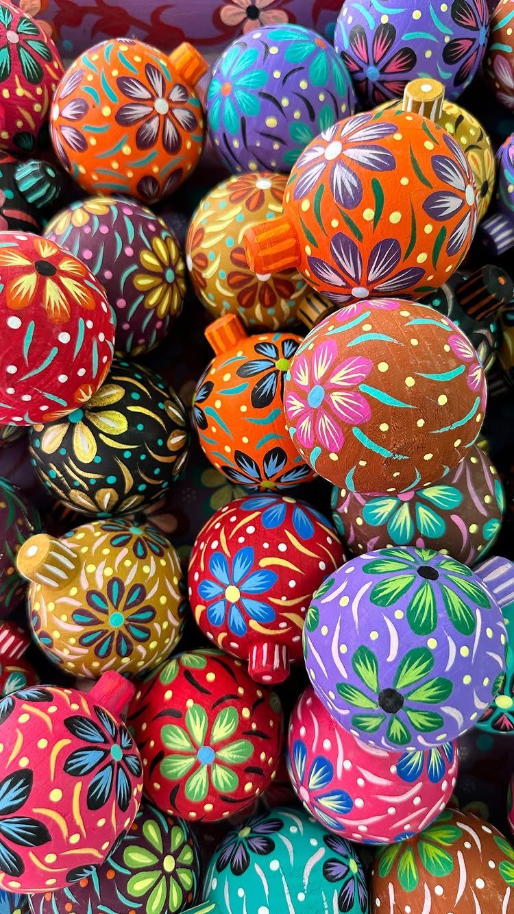 Colorful hand-painted wooden ornaments with vibrant floral patterns in various bright colors.