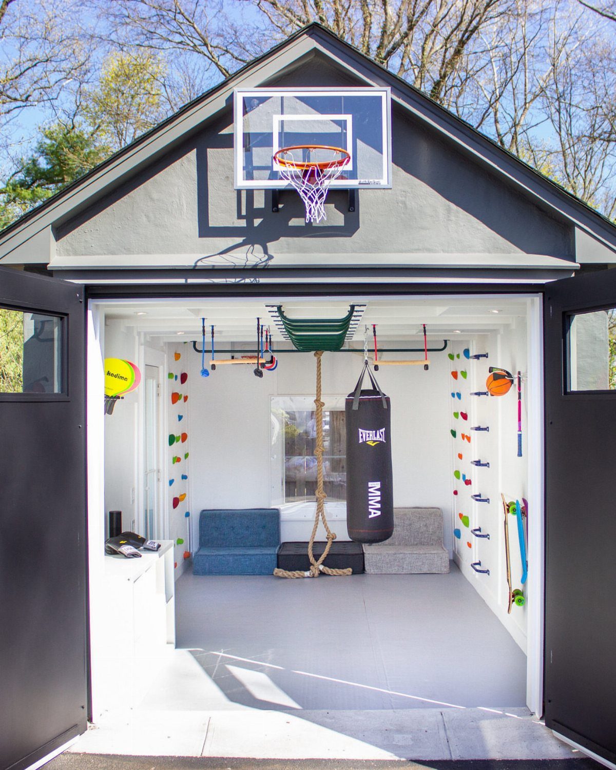 9 Multi Use Garage Ideas for Living, Work, and Play 6 A garage converted into an indoor play zone with a basketball hoop and climbing equipment.